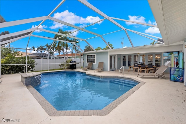 view of swimming pool with pool water feature, grilling area, glass enclosure, and a patio