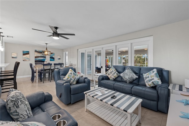 living room with french doors, ceiling fan, and light tile patterned floors