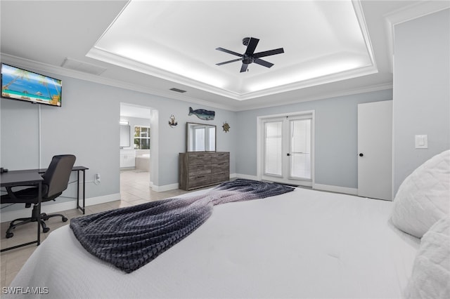 tiled bedroom with ensuite bath, ceiling fan, a tray ceiling, and ornamental molding