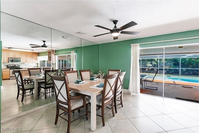 dining space with ceiling fan and light tile patterned flooring