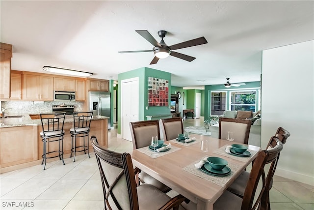 dining area with light tile patterned floors, ceiling fan, and sink