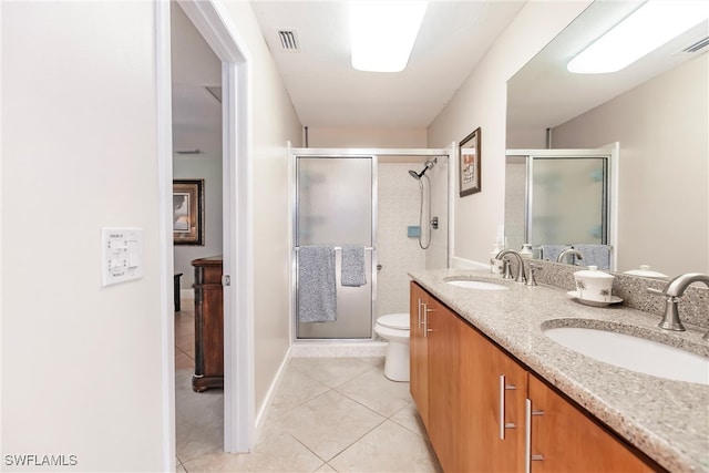 bathroom with tile patterned flooring, vanity, toilet, and walk in shower