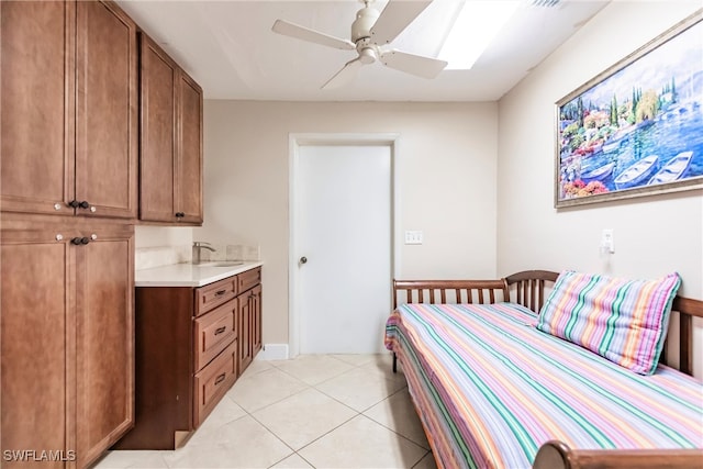 bedroom with ceiling fan, light tile patterned floors, and sink