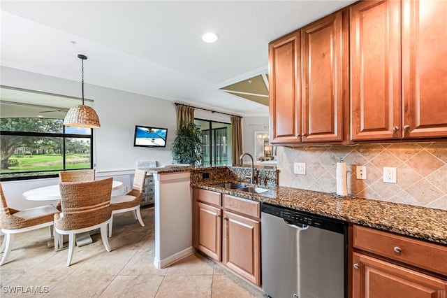 kitchen featuring hanging light fixtures, stainless steel dishwasher, dark stone countertops, and sink