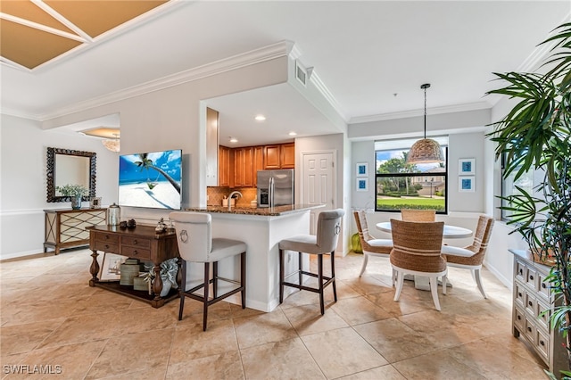 kitchen with ornamental molding, kitchen peninsula, stone countertops, stainless steel refrigerator with ice dispenser, and decorative backsplash