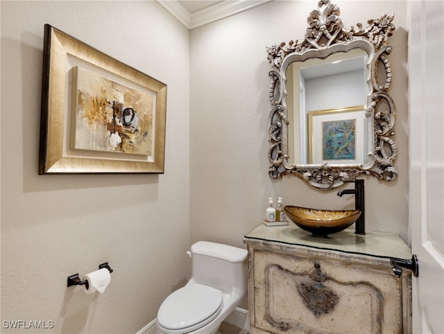 bathroom with ornamental molding, vanity, and toilet