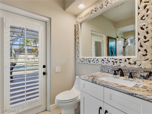 bathroom with toilet, vanity, and a shower