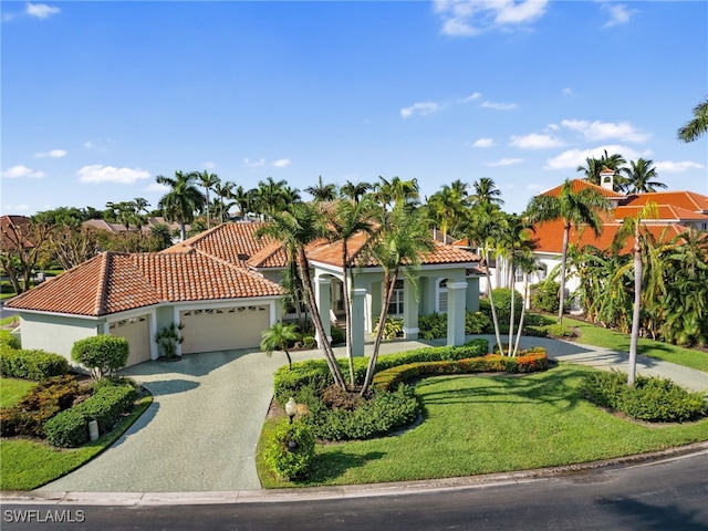 mediterranean / spanish home with a garage and a front lawn