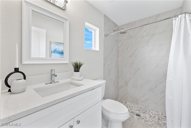 bathroom with walk in shower, vanity, and toilet