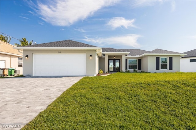 ranch-style home featuring a front lawn, a garage, and french doors