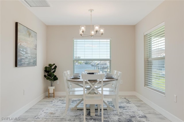 dining room featuring light hardwood / wood-style flooring and a notable chandelier