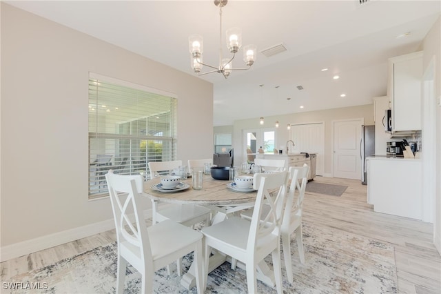 dining room featuring an inviting chandelier and light hardwood / wood-style flooring