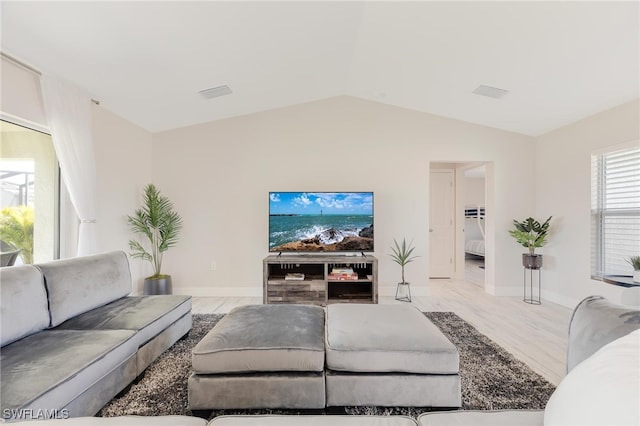 living room with light wood-type flooring and vaulted ceiling