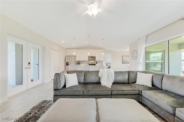 living room featuring ceiling fan, light wood-type flooring, lofted ceiling, and french doors