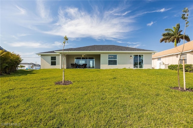 back of house featuring ceiling fan and a lawn