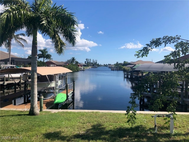 view of dock with a lawn and a water view