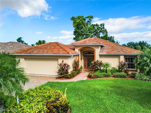 mediterranean / spanish-style house featuring a garage and a front lawn