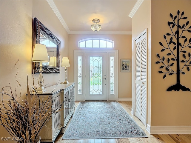 foyer entrance with light wood-type flooring and crown molding