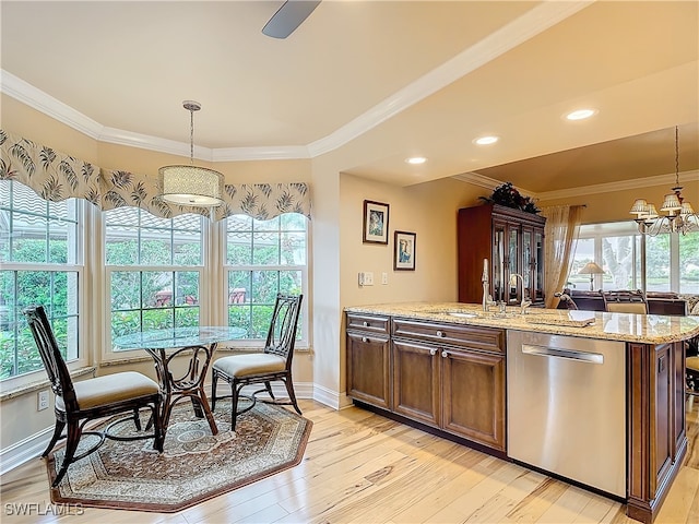 kitchen featuring light wood-type flooring, decorative light fixtures, dishwasher, and a wealth of natural light