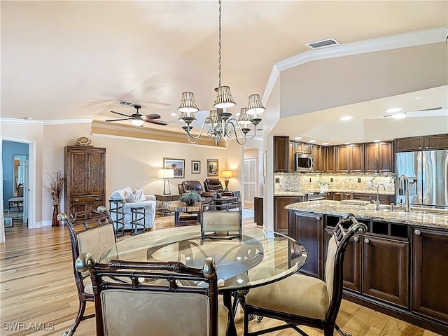 dining space featuring ceiling fan with notable chandelier, crown molding, and light hardwood / wood-style flooring