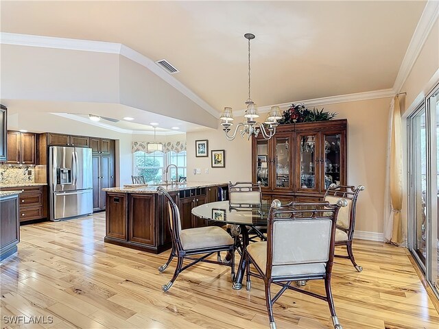 dining space with ornamental molding, a wealth of natural light, light hardwood / wood-style floors, and a notable chandelier