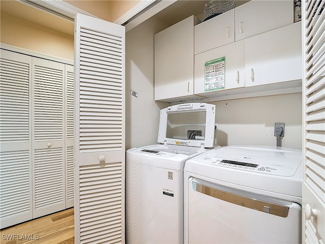 washroom featuring cabinets, light hardwood / wood-style floors, and independent washer and dryer