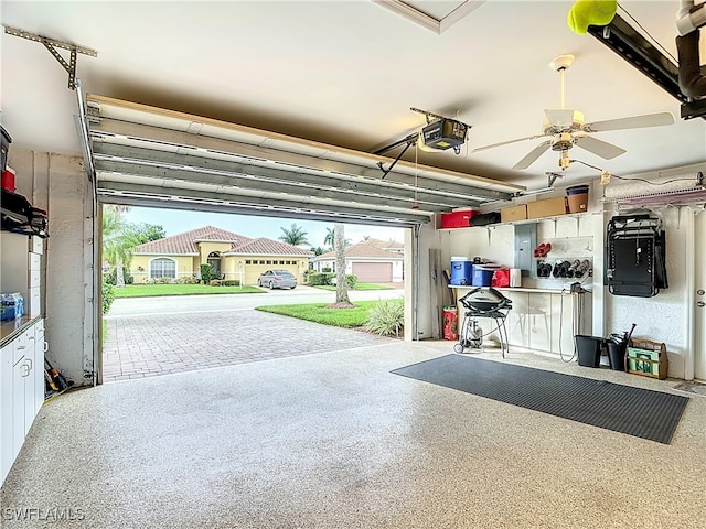 garage with a garage door opener, ceiling fan, and electric panel