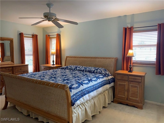 bedroom featuring light colored carpet, multiple windows, and ceiling fan