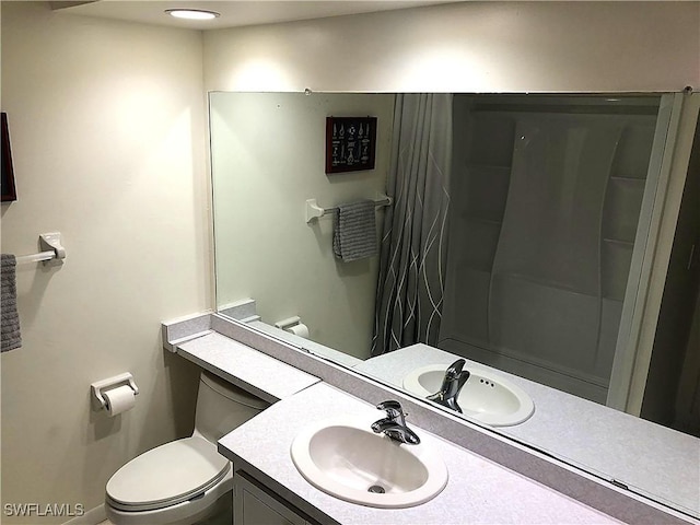 bathroom featuring curtained shower, vanity, and toilet