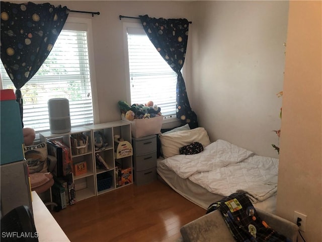 bedroom featuring hardwood / wood-style floors and multiple windows