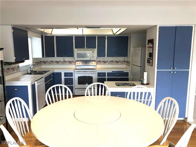 kitchen featuring blue cabinetry, appliances with stainless steel finishes, hardwood / wood-style floors, and sink