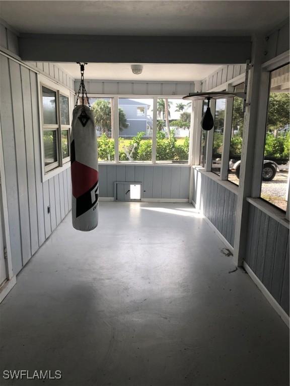 unfurnished sunroom featuring plenty of natural light and beam ceiling