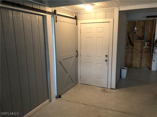 doorway to outside with a barn door and wood walls