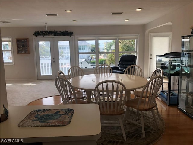 dining space with wood-type flooring and french doors