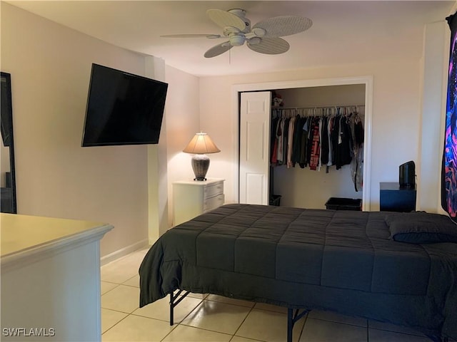 bedroom featuring ceiling fan, a closet, and light tile patterned floors