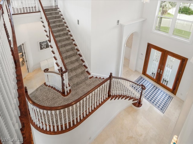 foyer entrance with french doors and a towering ceiling