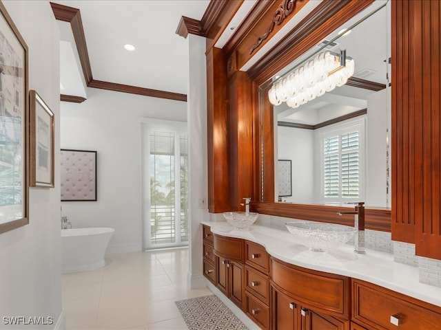 bathroom with a bath, vanity, a notable chandelier, ornamental molding, and tile patterned flooring