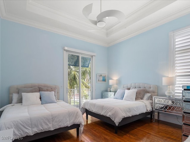 bedroom with crown molding, hardwood / wood-style floors, access to exterior, and a raised ceiling