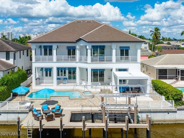 back of property with a patio, a water view, and a balcony