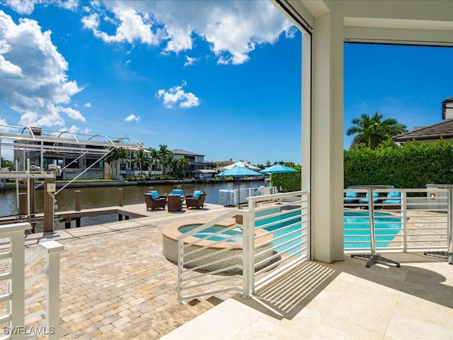 view of swimming pool with a patio area and a water view