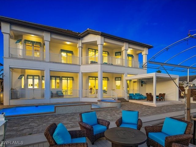 rear view of house with a patio, outdoor lounge area, and a balcony