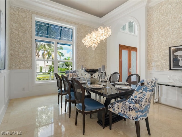 dining area featuring crown molding, french doors, and a chandelier