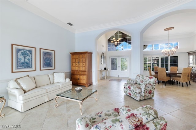 living room with crown molding, light tile patterned floors, a towering ceiling, and a chandelier