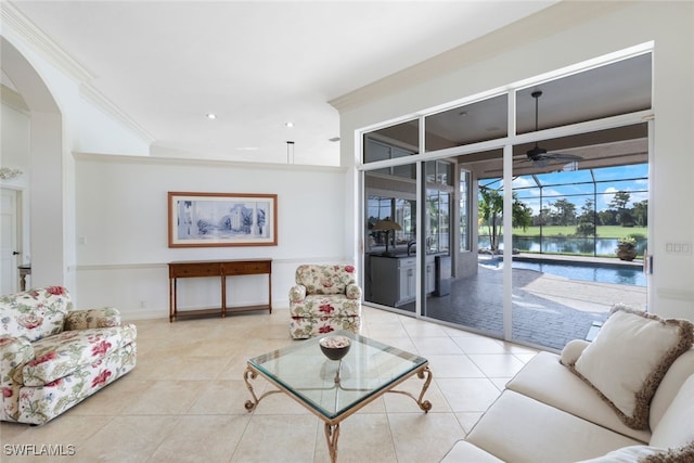 tiled living room with ornamental molding, a water view, and ceiling fan