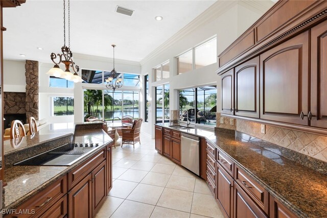 kitchen with sink, stainless steel dishwasher, decorative light fixtures, a chandelier, and a water view