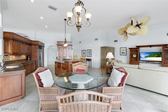 dining space featuring ornamental molding, light tile patterned floors, and sink