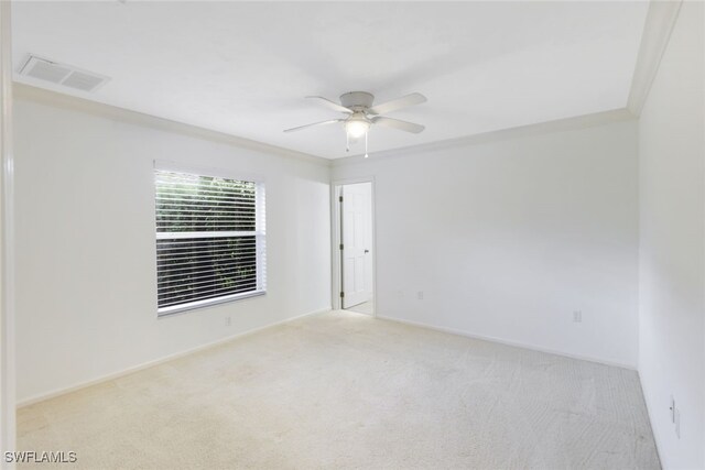 spare room featuring crown molding, light carpet, and ceiling fan