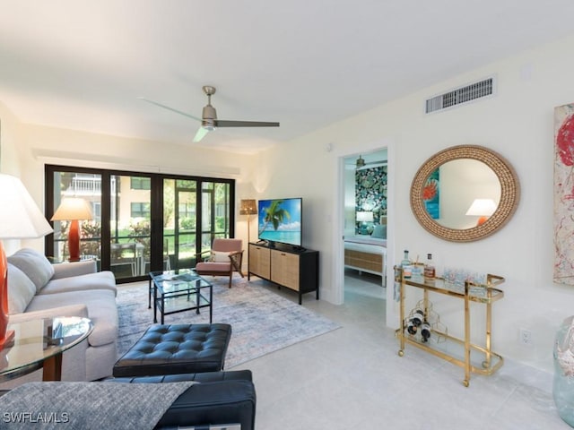 living room featuring ceiling fan and french doors