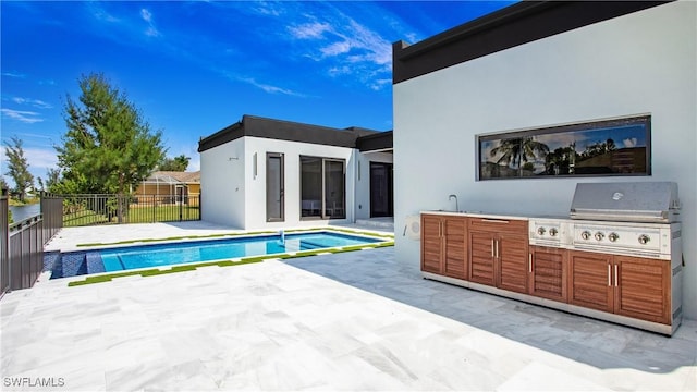 view of pool featuring a patio area, area for grilling, and exterior kitchen