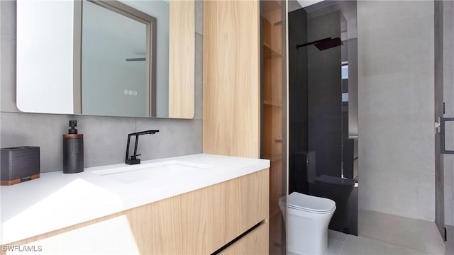 bathroom featuring toilet, vanity, backsplash, and a shower